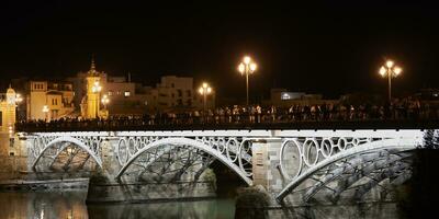 förtjusande semana tomten. fredag natt på triana bro, överfyllda med glad folkmassor foto