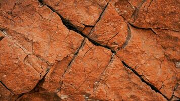 mörk röd orange brun sten textur med sprickor. närbild. grov berg yta. ai generativ. foto