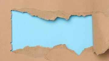 trasig kanter av brun papper på en blå bakgrund, Plats för skrivning foto