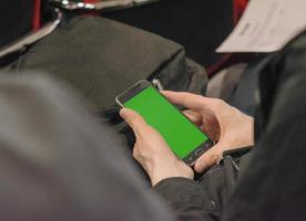 man använder smartphone med grön skärmknapp på affärspresentation. foto