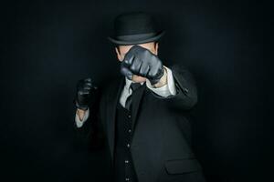 porträtt om herre i mörk kostym och kastare hatt kasta en stansa. årgång engelsk herre man av handling. foto
