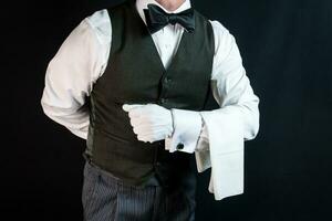 porträtt av butler eller servitör i väst och vit handskar med servett draperad över ärm. begrepp av professionell gästfrihet. foto