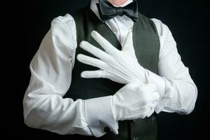 porträtt av butler eller concierge dragande på vit handskar. begrepp av service industri och professionell gästfrihet. foto