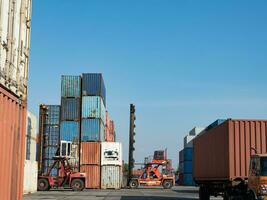 behållare blå orange Färg gaffeltruck kran frakt logistisk industri importera exportera leverans handel global läser in lastbil handel lagring Bra docka lager ekonomi över hela världen stack låda tung frakt fartyg foto