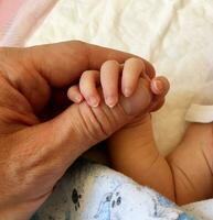 fotografi på tema far innehav hans nyfödd bebis tätt förbi hand i moderskap sjukhus foto