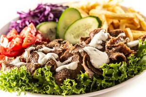 välsmakande turkiska kalvkött kebab eras med färsk grönsaker, sallad, franska bränder och härlig och utsökt dopp, majonnäs foto