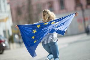 attraktiv Lycklig ung flicka med de flagga av de europeisk union foto