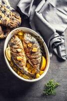 rostad medelhavs fisk braxen med potatisar rosmarin och citron- foto