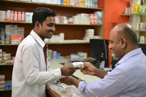 en apotekare i en apotek dispenserar mediciner till en kund foto