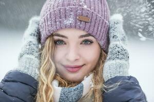 porträtt av ung skön kvinna i vinter- kläder och stark snöar foto