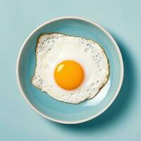 friterad ägg med gul äggula eras på blå keramisk tallrik foto