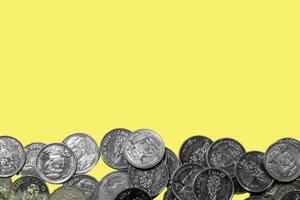 många mynt placerad på gul papper foto