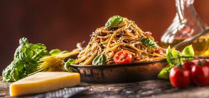 italiensk pasta spaghetti med tomat sås oliv olja basilika och parmesan ost i gammal panorera foto