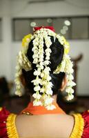 en traditionell javanese dansare bär mycket skön jasmin blommor i henne svart hår foto