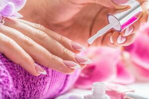 kvinna händer applicering vit nagel putsa i skönhet salong foto