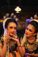 två javanese dansare i gul halsdukar tar bilder med löjlig ansikten foto