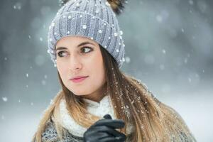 porträtt av ung skön kvinna i vinter- kläder och stark snöar. foto