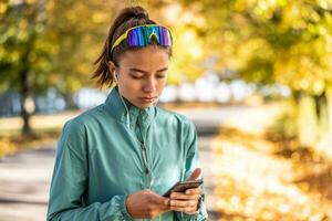 ung kvinna löpare lyssnande till motiverande musik på smartphone app foto