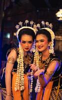 två javanese dansare i gul halsdukar tar bilder med löjlig ansikten foto