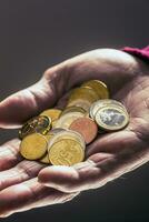 pensionär man innehav i händer euro mynt. tema av låg pensioner foto