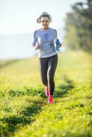 ung sportig kvinna löpning i natur. morgon- Träning sports foto