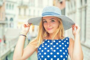Lycklig ung attraktiv kvinna mode modell av Venedig Italien i blå polka punkt utrusta foto