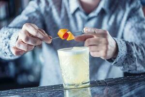 professionell bartender framställning cocktail dryck och dekorerad med frukter. foto