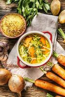 kyckling soppa buljong i en årgång skål med hemlagad spaghetti morot lök selleri örter vitlök och färsk grönsaker. foto