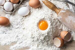 topp se av ägg äggula, mjöl, och vält på kök tabell foto