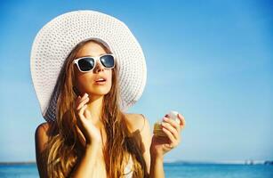en kvinna i en hatt och solglasögon på de strand foto