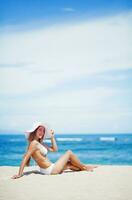 en kvinna i en bikini och hatt på de strand foto