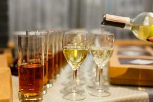 vit vin varelse hällde in i vin glas i restaurang. uppsättning av glasögon med juice foto