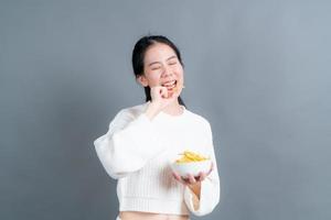 ung asiatisk kvinna äter potatischips