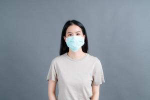 asiatisk kvinna som bär medicinsk ansiktsmask skyddar filterdamm pm2.5 anti-förorening, anti-smog och covid-19