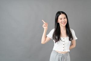 asiatisk kvinna med leende ansikte och hand som presenterar på sidan foto
