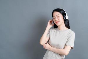 ung asiatisk kvinna som lyssnar på musik med hörlurar foto