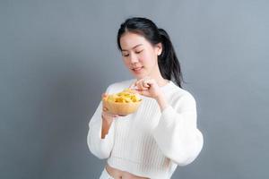 ung asiatisk kvinna äter potatischips