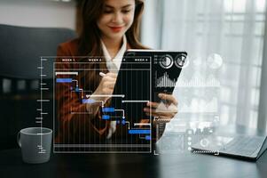 affärsman hand projekt chef arbetssätt och uppdatering uppgifter och gantt Diagram schemaläggning virtuell diagram.med smart telefon, läsplatta och bärbar dator i kontor. foto