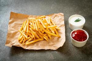 pommes frites med gräddfil och ketchup foto