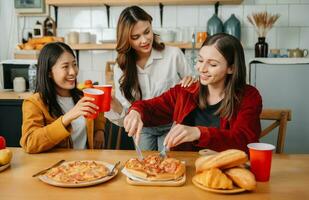 grupp av vänner framställning roligt på Hem festa.de Sammanträde på skrivbord i levande rum och äter pizza. foto