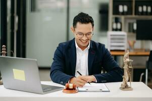 rättvisa och lag begrepp .asiatiska manlig bedöma i en rättssal på tabell och rådgivare arbetssätt i modern kontor. foto