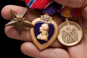 man innehav lila hjärta, brons och nationell försvar krig medaljer foto