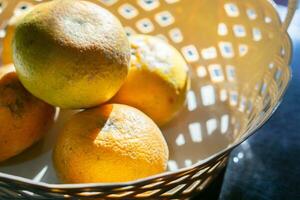 färsk och mogen sunkist apelsiner frukter. eras i rotting korg. foto
