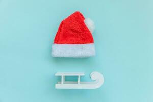 helt enkelt minimal sammansättning jul santa claus hatt kälke isolerat på blå pastell färgrik trendig bakgrund foto