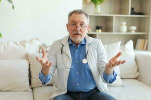 senior man läkare prata på video ring upp ha samråd med patient se på kamera webbkamera. professionell senior mogna sjukvård expert- granskning patient uppkopplad. sjukvård begrepp. webbkamera se. foto