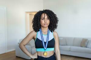 beskurna porträtt av ett attraktiv ung kvinna idrottare Framställ med henne guld medalj ut foto
