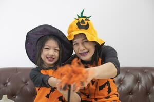 mor och dotter i halloween kostymer har roligt på Hem. foto