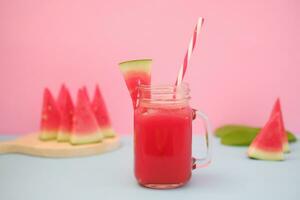 vattenmelon smoothie i en glas burk med strån som en bakgrund foto