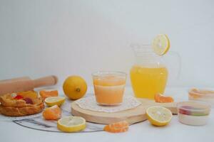 färsk orange juice i en glas med färsk frukt på en vit bakgrund foto