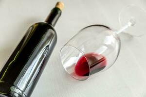 glas och flaska med röd vin foto